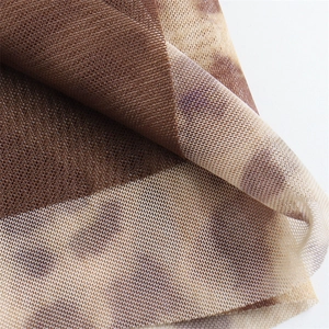 Macro view of semi-transparent mesh fabric with a brown tie-dye texture and honeycomb pattern