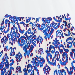 Détail de la taille avec imprimé ikat bleu et bouton sur le pantalon d'été blanc