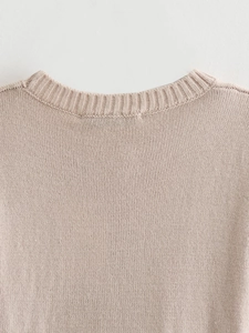 Detail of soft ribbed crew neck and fine knit texture on a light pink summer top
