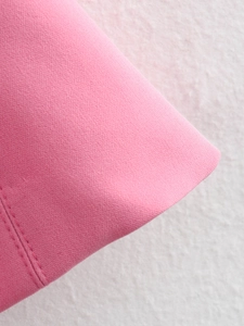 Close-up of bright pink fabric texture and high-quality double-needle stitching detail