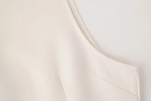Gros plan sur les coutures précises et le tissu tissé d'une robe d'été beige chic