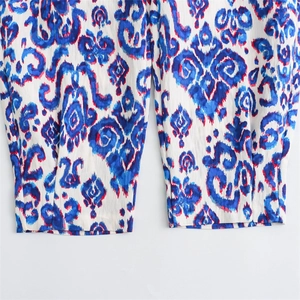 Détail de l'imprimé ikat bohème bleu et blanc sur le tissu du pantalon d'été