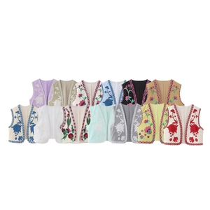 Flat lay view of bohemian embroidered vests in various vibrant colors for women