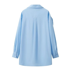 Detailed back view of a light blue long-sleeve shirt with yoke and box pleat details