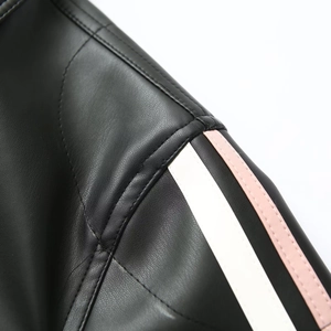 Détail d'épaule de veste en cuir noir avec rayures décoratives blanches et roses