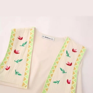 Vintage beige sleeveless vest with floral embroidery and geometric trim details
