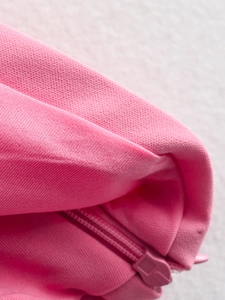 Close-up of pink knitted fabric texture with matching invisible zipper detail