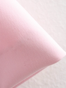 Nahaufnahme des rosa Stoffes der Falten-Shorts mit Fokus auf die feine Webstruktur