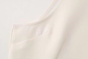 Gros plan sur le tissu tissé de qualité et les coutures soignées d'une robe d'été crème
