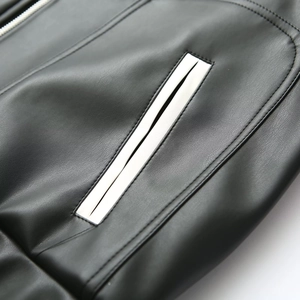 Vue rapprochée de la poche en cuir noir avec passepoil blanc contrasté sur la veste