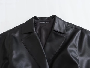 Gros plan sur le revers classique et l'étiquette d'une veste en similicuir noir femme
