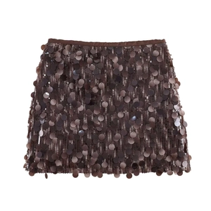 Detail of dark brown sequin mini skirt showing large metallic paillettes and satin waistband
