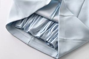 Close-up of high-quality stitching and pleated lining on a light blue summer dress