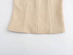 Dettaglio dell'orlo del top senza maniche beige con cuciture verticali e rifiniture