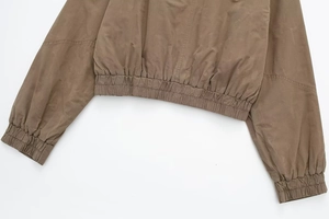 Detail of elastic hem and ribbed cuffs on the brown bomber jacket with clean stitching