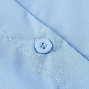 Detailed macro view of light blue shirt fabric texture and matching four-hole round button