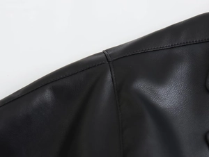 Vue macro détaillée des coutures d'épaule et de la texture de couture de la veste en cuir noir