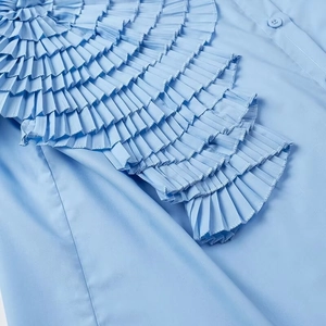 Detail of multi-layered pleated 3D floral design on light blue long-sleeve cotton shirt