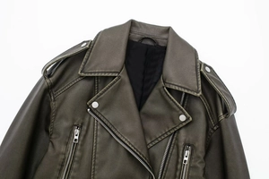 Detail shot of vintage olive green biker jacket showing lapels and distressed leather texture