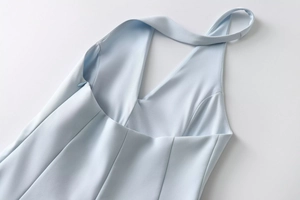 Detail of light blue halter dress showing invisible side zipper and precise stitching