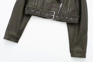 Macro detail of vintage olive green PU leather jacket with silver zipper and buckle