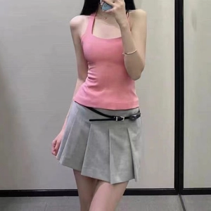 Slim fit pink halter top paired with a pleated grey mini skirt and a black belt