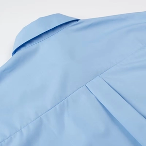 Macro shot of light blue shirt showing box pleat and detailed stitching on the back yoke