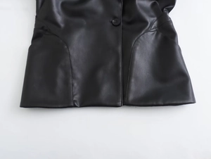 Détail d'une veste en cuir noir avec fermeture à bouton et coutures de poche courbées