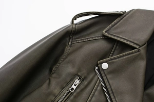 Detailed close-up of distressed faux leather jacket featuring silver zippers and hardware