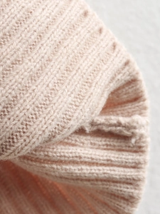 Detailed macro view of the soft pink ribbed knit texture on a short-sleeve summer top