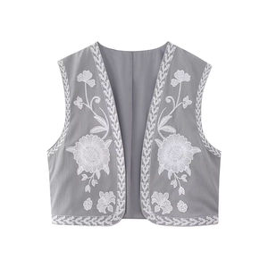Detailed close-up of grey vintage embroidered vest featuring white floral patterns