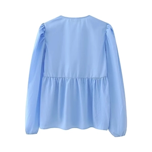 Detail of light blue babydoll top with puff sleeves and pleated waist from rear view