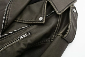 Close-up of vintage dark PU leather biker jacket with metal zipper and silver snap buttons
