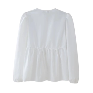 Detailed back view of white long-sleeved babydoll shirt with gathered pleats and hem