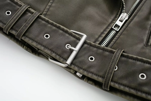 Detail of faux leather biker jacket featuring a silver metal belt buckle and vintage texture