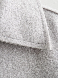 Detailed close-up showing thick light grey curly fleece texture and neat stitching seams