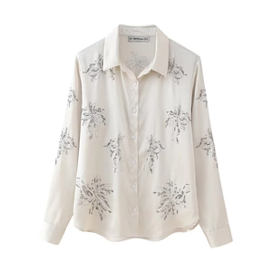Detailed embroidery of gray palm leaf patterns on off-white long sleeve silk shirt