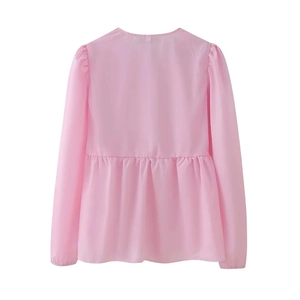Rear view of a pink long-sleeved peplum blouse with ruffled hem and minimalist round neck