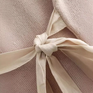 Women's pink knit short sleeve top featuring a delicate decorative bow detail