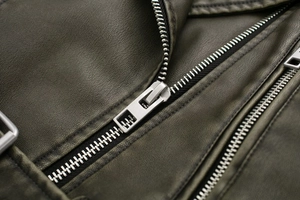 Close-up of olive green PU leather jacket showing grain texture and silver metal zipper