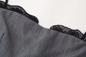 Detail of dark grey satin fabric with delicate black lace trim on the neckline