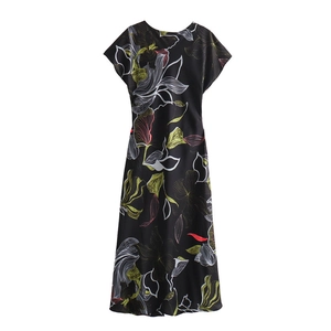 Detailed view of the artistic floral print on black midi dress with yellow leaf motifs