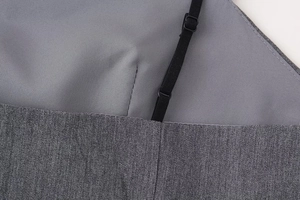Detailed close-up of dark grey satin fabric with adjustable black shoulder strap buckle