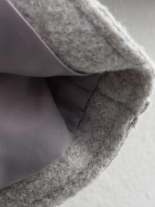 Macro detail of plush grey faux shearling fabric with smooth satin lining texture