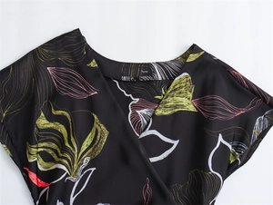 Close-up of the V-neckline and floral print on the black satin midi dress fabric