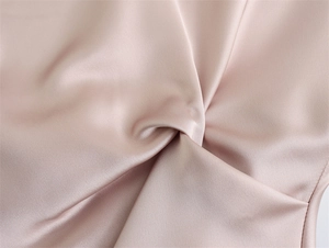 Vue détaillée du tissu en satin rose champagne avec un nœud élégant pour robe de femme