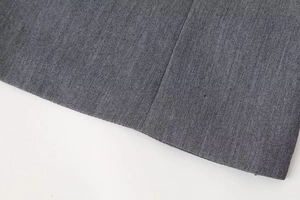 Detailed macro view of dark grey twill fabric texture and stitching on summer top