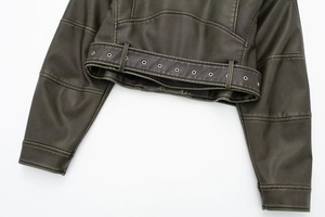 Detail of faux leather biker jacket hem featuring metallic eyelet belt and stitching