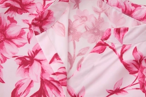 Nahaufnahme des V-Ausschnitts einer floralen Schifferbluse mit rosa Rosendruck und Nähten