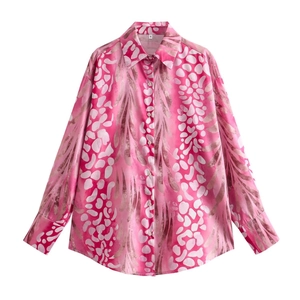 Detail of pink patterned shirt collar with size S label and button-down front closure